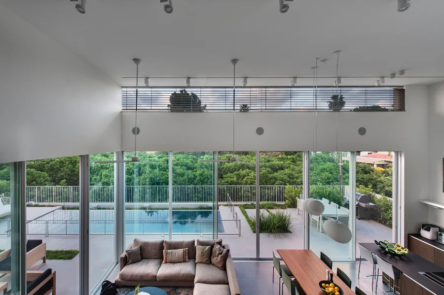 Living room with seating, tables and large windows.