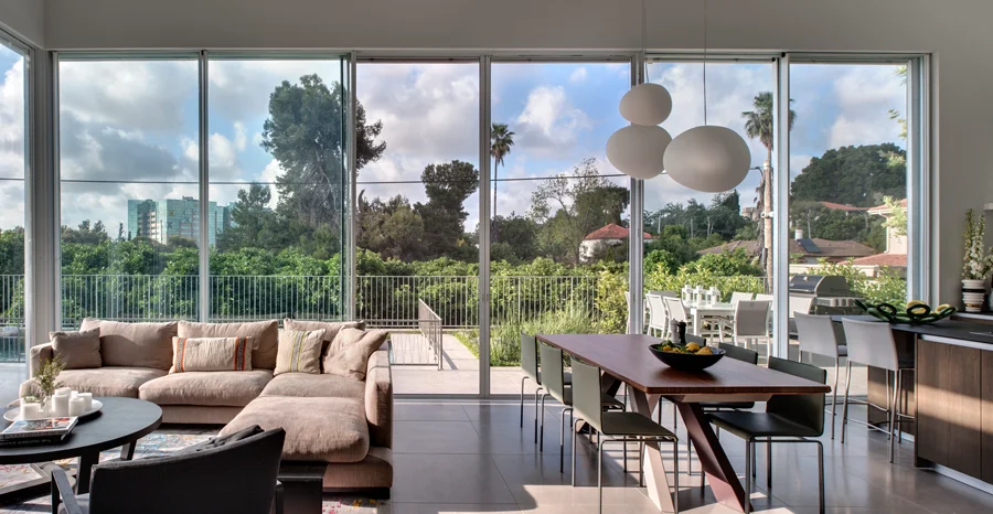 Open living and dining space with seating, a dining table and large windows.