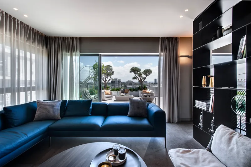 Living room with seating, tables and large windows.