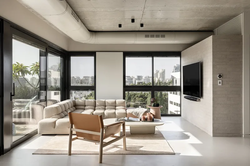 Living room with seating, tables and large windows.