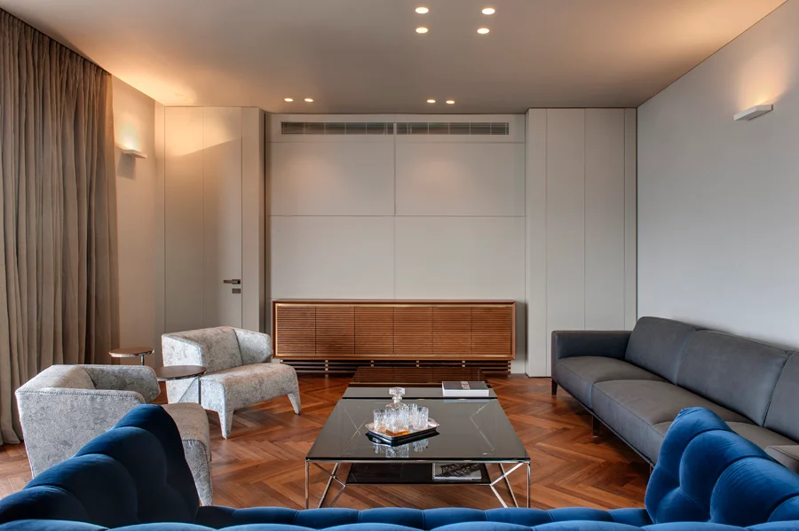 Living room with seating, tables and large windows.