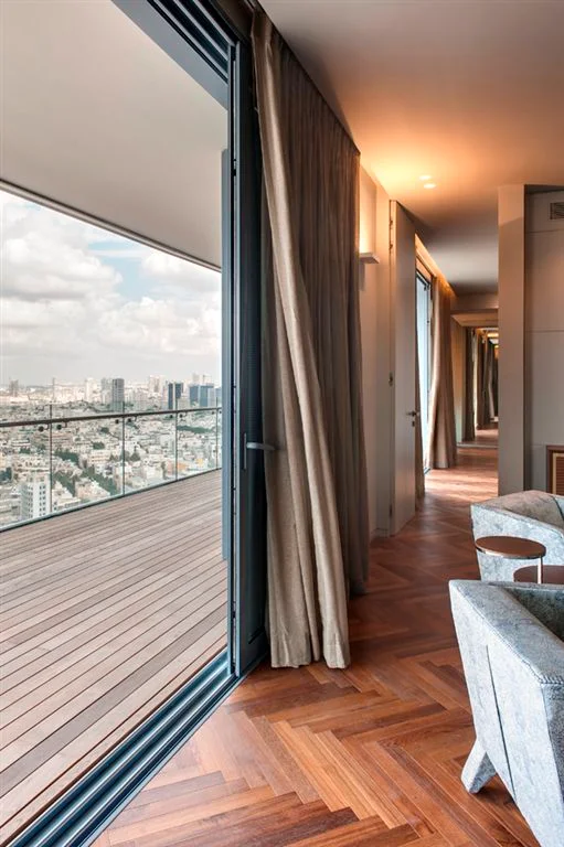 View through a window or glazed opening towards the surrounding landscape.