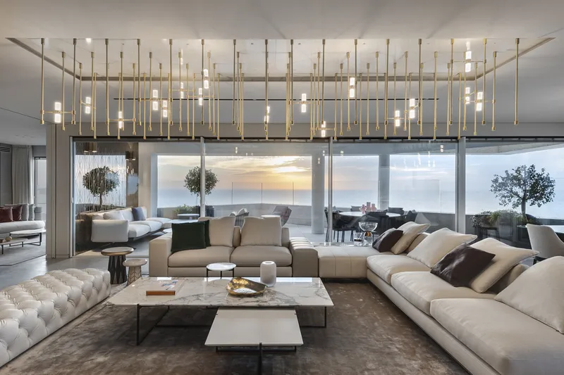 Living room with seating, tables and large windows.
