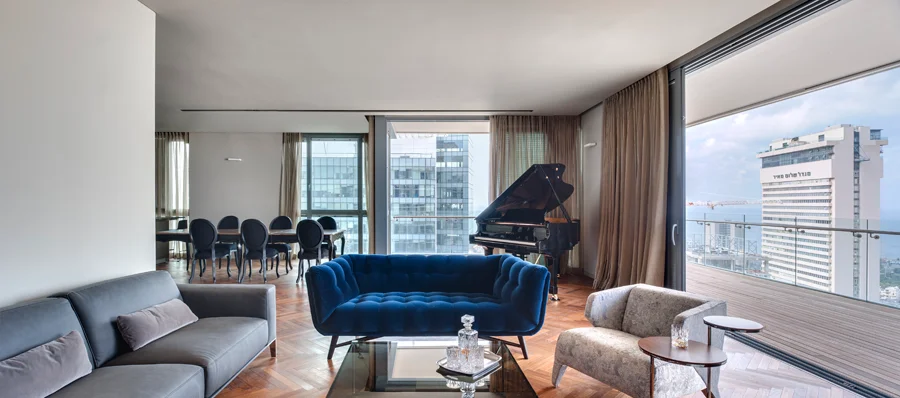 Living room with seating, tables and large windows.