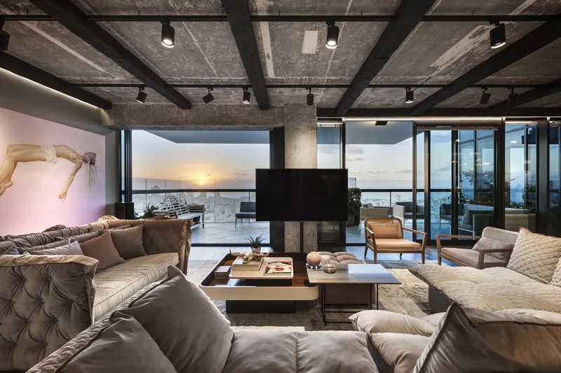 Living room with seating, tables and large windows.