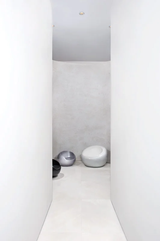 Interior passage showing doorways, walls and light from adjoining spaces.