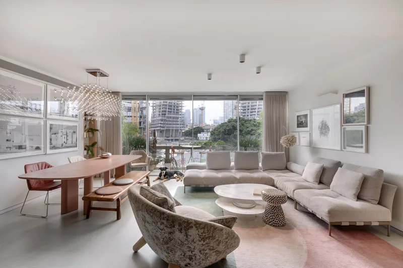 Open living and dining space with seating, a dining table and large windows.