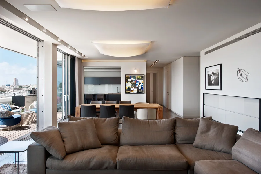 Living room with seating, tables and large windows.