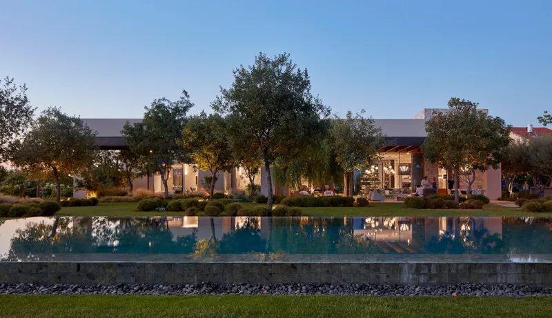 Exterior view at dusk or night, with illuminated spaces.
