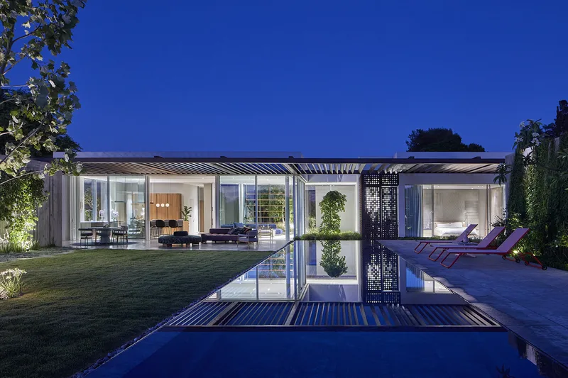 Exterior view at dusk or night, with illuminated spaces.