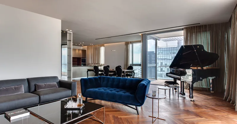 Living room with seating, tables and large windows.