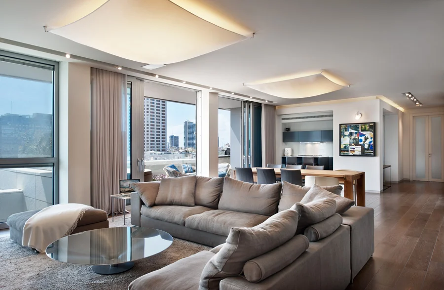 Living room with seating, tables and large windows.