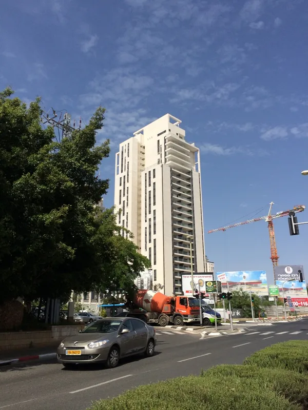 Exterior view of a tall residential building and its surroundings.